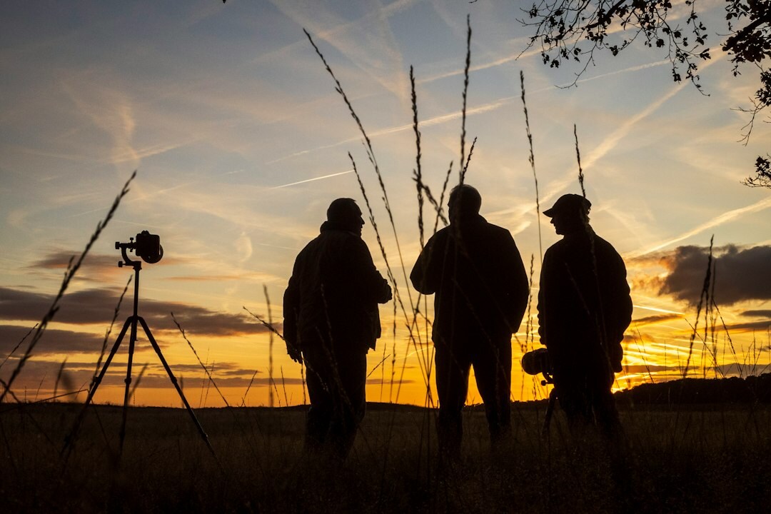 Team of three documentary photographers standing outdoors with cameras
